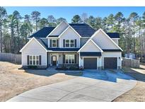 Charming two-story home featuring a well-manicured front yard and a spacious two-car garage at 131 Southbrook Ln, Sanford, NC 27332