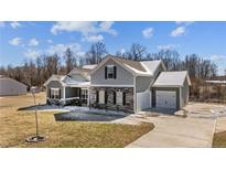 Charming two-story home featuring stone accents, a two-car garage, and a well-manicured front lawn at 208 Planters Ln, Coats, NC 27521