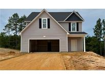 Charming two-story home with a spacious two-car garage and light gray siding on a partly landscaped lot at 265 Harborwood St, Lillington, NC 27546