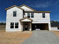 New two-story home featuring an attached two-car garage, and covered entryway, set against a bright blue sky at 269 Greenbay Street St, Lillington, NC 27546