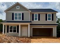 Charming two-story home with neutral siding, black shutters, and an attached two-car garage at 305 Harborwood St, Lillington, NC 27546