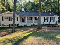 Charming single-story home featuring a white brick facade, black shutters, and a well-manicured front yard at 374 S Denise Ave, Coats, NC 27521