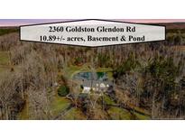 Secluded home on 10+ acres with a private pond, surrounded by lush greenery and mature trees at 2360 Goldston Glendon Rd, Goldston, NC 27252