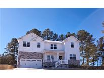 Charming two-story home featuring a covered porch, a two-car garage, and a well-maintained front yard at 38 Cedarview Ct, Cameron, NC 28326