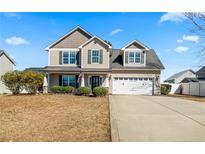 Charming two-story home featuring a two-car garage and welcoming front porch at 219 Regimental Dr, Cameron, NC 28326