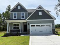 Charming two-story home featuring a two-car garage, well-maintained lawn and appealing craftsman style architecture at 22 Peach Orchard (Lot 1) Ln, Lillington, NC 27546