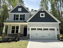 Charming two-story home with stone accents, a covered porch, and a two-car garage at 62 Peach Orchard (Lot 3) Ln, Lillington, NC 27546