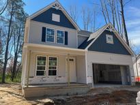 Charming two-story home featuring a covered front porch and an attached garage at 62 Peach Orchard (Lot 3) Ln, Lillington, NC 27546