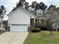 Charming home featuring a two-car garage and well-manicured front yard with mature trees at 147 Lamplighter Way, Spring Lake, NC 28390