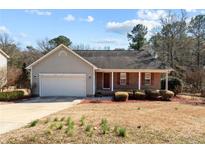 Charming single-story home with brick and vinyl siding, a well-maintained yard, and an attached garage at 140 Cobblestone Dr, Spring Lake, NC 28390