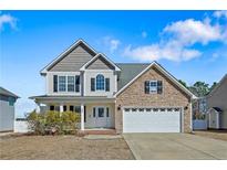 Charming two-story home with stone accents, attached garage, and well-manicured lawn at 25 Trenton Place, Cameron, NC 28326