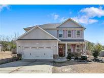 Charming two-story home featuring a two-car garage, lovely landscaping and shuttered windows at 151 New Castle Ln, Spring Lake, NC 28390