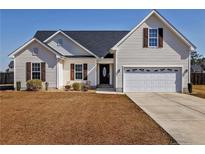 Charming one-story home with a two-car garage, and well-manicured lawn at 199 Carolina Oaks Dr, Linden, NC 28356