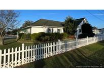 Charming home with a white picket fence and mature landscaping at 210 E E St, Erwin, NC 28339