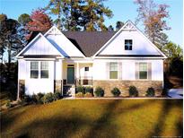 Charming, new construction two-story home featuring a manicured lawn and stone accents, perfect for suburban living at 503 Boulderbrook Pkwy, Sanford, NC 27330