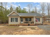 Charming single-story home featuring a cozy front porch, neutral siding, and well-maintained landscaping at 640 Lanier Farm Rd, Sanford, NC 27330