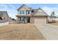 Charming two-story home with a two-car garage and well-manicured lawn at 100 Tripoli Dr, Cameron, NC 28326