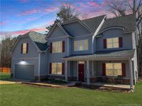 Charming two-story home with gray siding, red shutters, manicured lawn, and inviting front porch at 109 Mosby Ln, Spring Lake, NC 28390