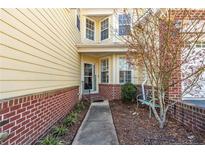 Inviting home entrance featuring a yellow exterior, red brick accents, and a charming welcome sign at 82 Pine Hawk Dr, Spring Lake, NC 28390