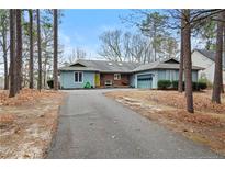 Charming single-story home with light blue siding, attached garage, and a welcoming front porch at 95 Fairway Ln, Sanford, NC 27332