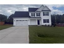 Charming two-story home with a well-manicured lawn and a two-car garage at 122 Reece Dr, Sanford, NC 27332