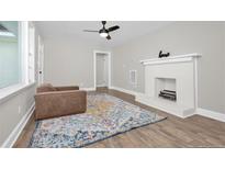 Bright living room featuring a white fireplace, stylish rug, and hardwood floors at 500 S 13Th St, Erwin, NC 28339