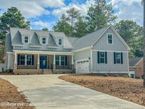 Charming two-story home with gray siding, dormers, and well-manicured landscaping at 515 Sanctuary Trl, Cameron, NC 28326