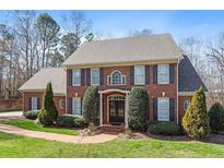 Charming two-story brick home with a well-manicured lawn and beautiful landscaping at 105 Royal Glen Dr, Cary, NC 27518