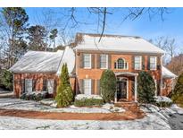 Beautiful brick home with manicured landscaping and snow-covered roof, creating a picturesque winter scene at 105 Royal Glen Dr, Cary, NC 27518