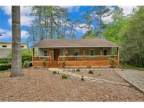 Charming home with a welcoming front porch, steps, wood accents and professionally landscaped yard at 1393 Pennsylvania Ave, Sanford, NC 27332