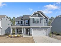 Charming two-story home featuring a two-car garage and a welcoming front porch at 169 Kensington Dr, Spring Lake, NC 28390