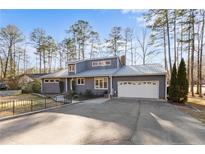 Charming single-story home featuring gray siding, a metal roof, attached garage and beautifully landscaped yard at 527 Perth Dr, Sanford, NC 27332