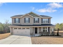 Charming two-story home with a manicured lawn and attached two-car garage at 715 New Castle Ln, Spring Lake, NC 28390