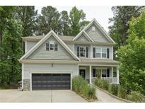 Charming two-story home with grey siding, black shutters, two-car garage and a well manicured lawn at 718 Creekside Dr, Sanford, NC 27330