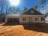 Charming single-story home with a covered front porch and attached two-car garage awaiting its finishing touches at 84 Peach Orchard (Lot 4) Ln, Lillington, NC 27546