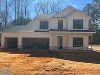 An incomplete white two-story home featuring a large three-car garage and covered porch on a sunny day at 96 Peach Orchard (Lot 5) Ln, Lillington, NC 27546