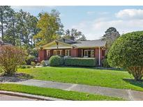 Charming brick home with a manicured lawn and mature landscaping creating beautiful curb appeal at 205 N Gulf St, Sanford, NC 27330