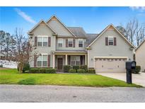 Charming two-story home with landscaped front yard, inviting entrance, and attached two-car garage at 103 Coopers Creek Ave, Spring Lake, NC 28390