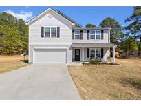 Charming two-story home with a well-manicured front yard and attached garage, great curb appeal at 15 Summerwood Ln, Lillington, NC 27546