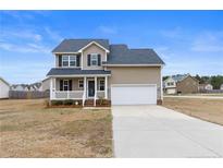Charming two-story home with a well-maintained front lawn and attached two-car garage at 24 Emma Ct, Linden, NC 28356
