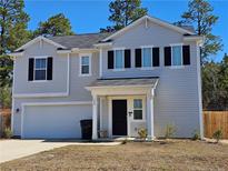 Charming two-story home with light gray siding, black shutters, and attached two car garage at 280 Hallow Oak Dr, Spring Lake, NC 28390