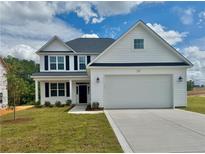 Charming two-story home with white siding, black shutters, and a well-manicured lawn on a sunny day at 46 Pikewood Ct, Lillington, NC 27546