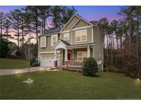 Inviting two-story home with a charming front porch and well-maintained landscaping at 63 Slate Dr, Spring Lake, NC 28390