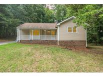 Charming single-story home featuring a welcoming front porch and manicured lawn surrounded by mature trees at 713 Harold Dr, Durham, NC 27712