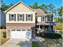 Charming two-story home with a stone-accented front, manicured lawn, and a two-car garage at 207 Heather Brook Cir, Spring Lake, NC 28390