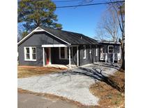 Charming single story home features a modern color palette and a well-maintained gravel driveway at 311 Saunders St, Sanford, NC 27330