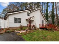 Charming home featuring white siding, a cozy front porch, and a well-manicured lawn with mature trees at 441 Windy Bch, Sanford, NC 27332