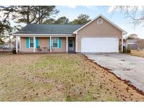 Charming single story home featuring a two car garage and inviting front porch at 639 Riverwind Dr, Spring Lake, NC 28390