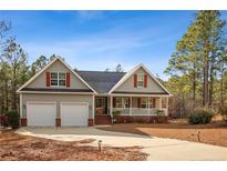 Charming single-Gathering home featuring a two-car garage, welcoming porch, and beautifully landscaped front yard at 15 Clearwater Hbr, Sanford, NC 27332