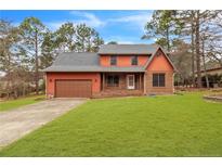 Charming two-story home with a well-maintained lawn, attached garage, and inviting entryway at 28 Ravens Wood Cir, Sanford, NC 27332